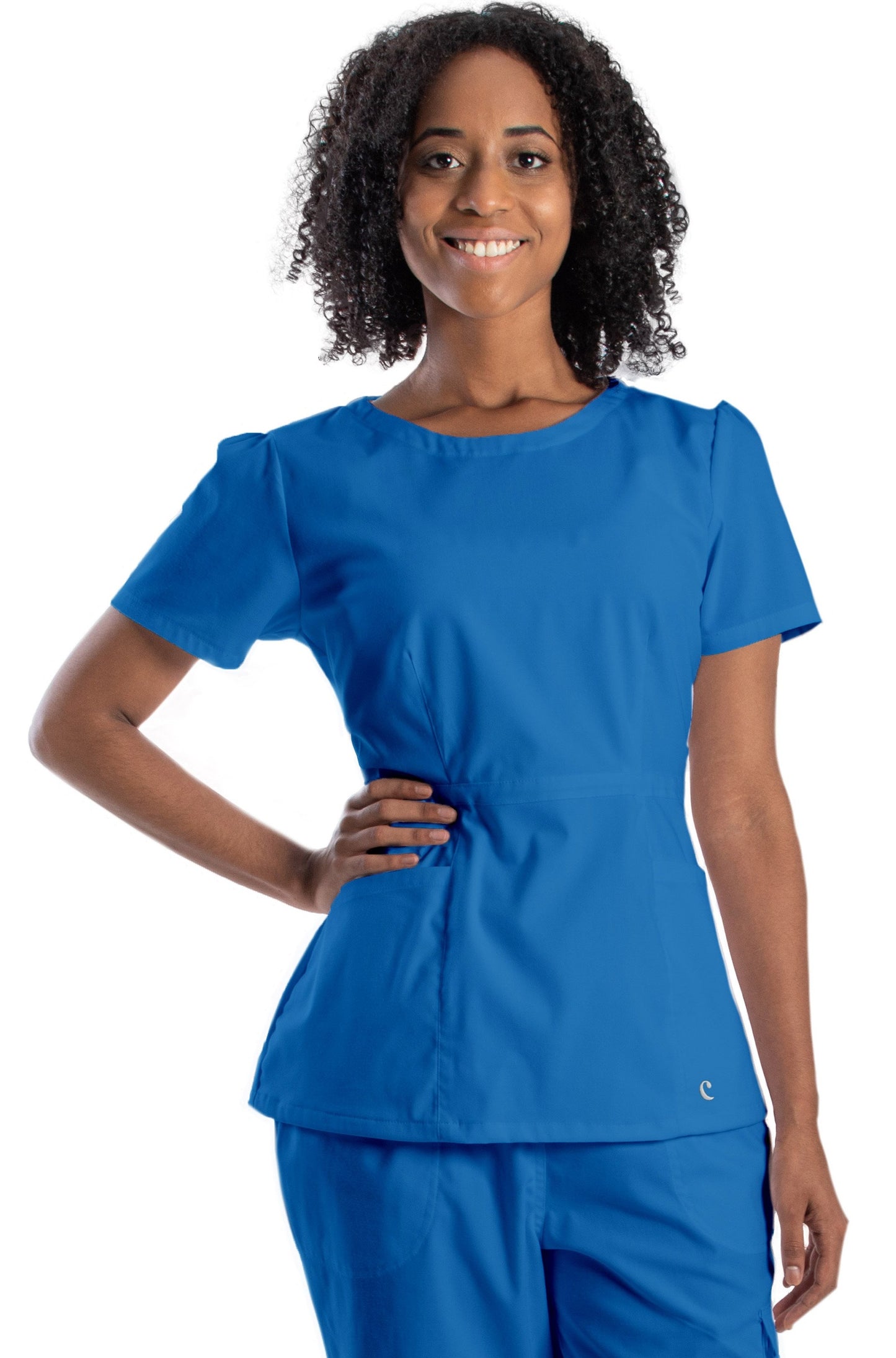 mujer usando filipina color azul rey de uso médico o para spa. La filipina tiene pinzas en la cintura, fruncido en las mangas, cuello redondo, y cierre lateral.
