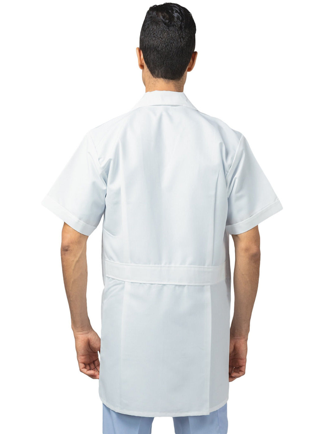 Hombre de espaldas vistiendo bata blanca de laboratorio de manga corta, largo tres cuartos, con tres bolsas al frente, cinto pegado en la espalda, y tablones invertidos. 