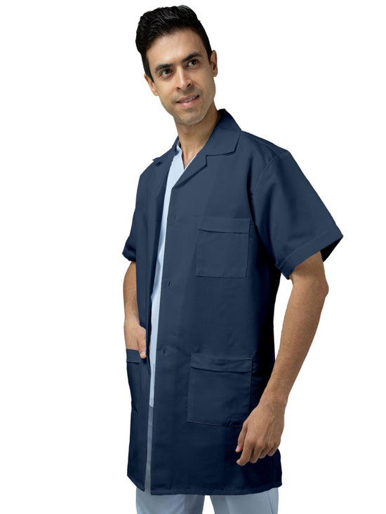 Hombre de espaldas vistiendo bata azul marino de laboratorio de manga corta, largo tres cuartos, con tres bolsas al frente, cinto pegado en la espalda, y tablones invertidos. 
