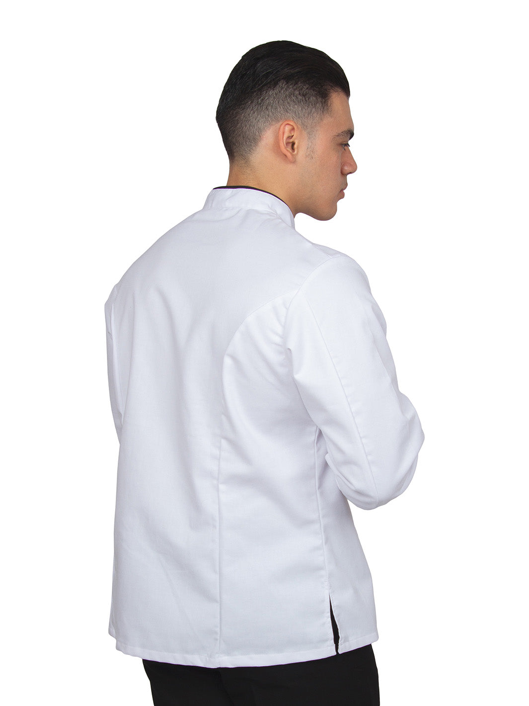 Hombre vistiendo filipina de chef unisex color blanco con vistas negras, mangas de puño redondeado, doble fila de botones con cruce reversible, y bolsa en manga izquierda. 