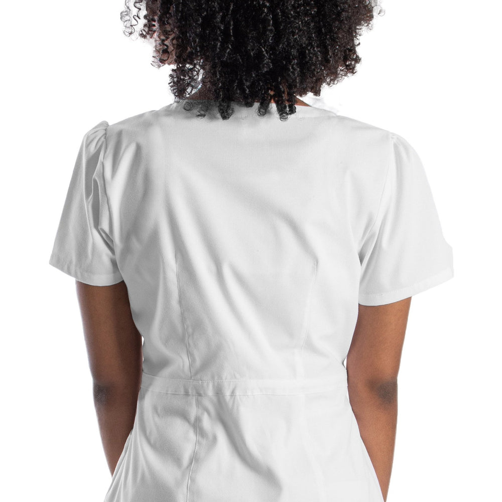 
                      
                        Mujer de espaldas usando filipina color blanco de uso médico o para spa. La filipina tiene pinzas en la cintura, fruncido en las mangas, cuello redondo, y cierre lateral.
                      
                    