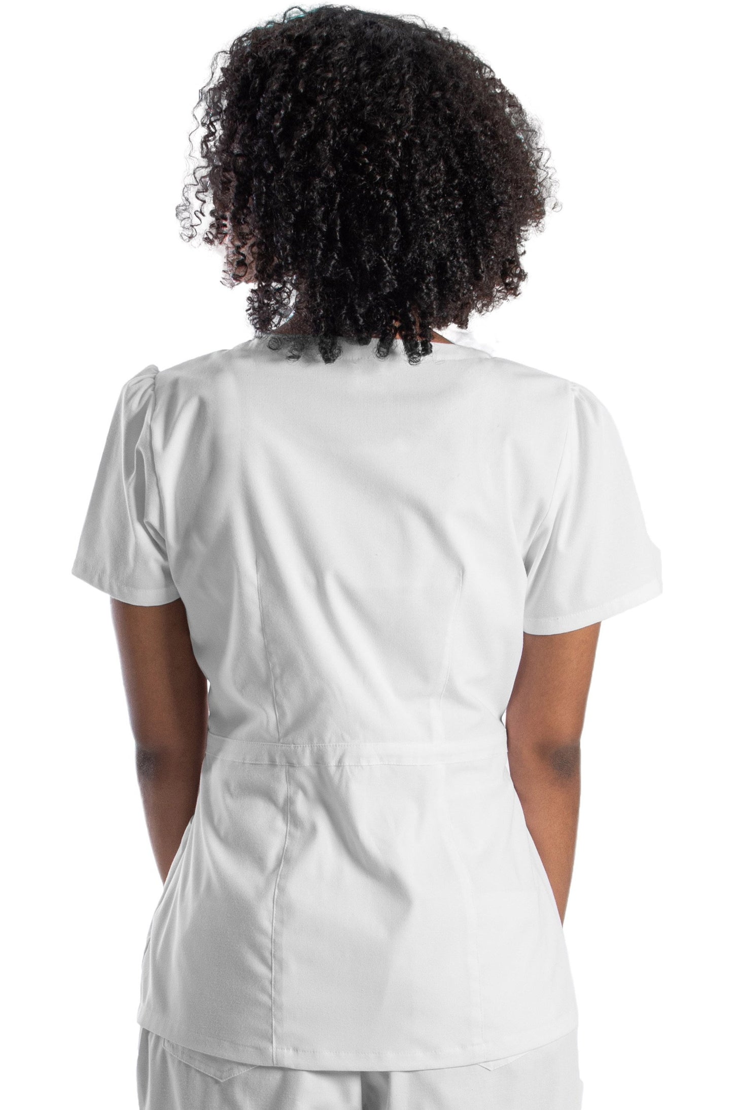 Mujer de espaldas usando filipina color blanco de uso médico o para spa. La filipina tiene pinzas en la cintura, fruncido en las mangas, cuello redondo, y cierre lateral.